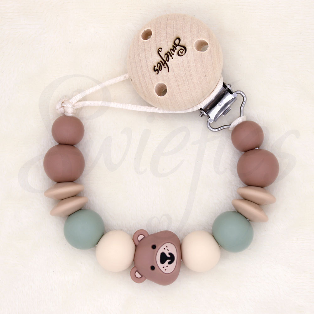 Speenkoord met beertje, gemaakt van siliconen kralen in crème, beige, bruine en groene kleuren, met een houten clip om veilig aan kleding te bevestigen, ideaal voor baby’s om speen niet te verliezen, de beer is bruin van kleur.