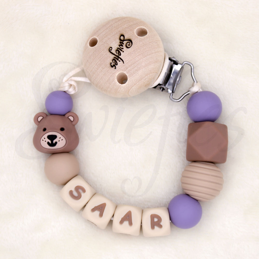 Speenkoord met naam Saar, gemaakt van siliconen kralen in crème, beige, bruine en paarse kleuren, een schattig beertje, met een houten clip om veilig aan kleding te bevestigen, ideaal voor baby’s om speen niet te verliezen, de beer is bruin van kleur.