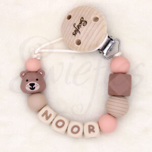 Speenkoord met naam Noor, gemaakt van siliconen kralen in crème, beige, bruine en Zalmroze kleuren, een schattig beertje, met een houten clip om veilig aan kleding te bevestigen, ideaal voor baby’s om speen niet te verliezen, de beer is bruin van kleur.