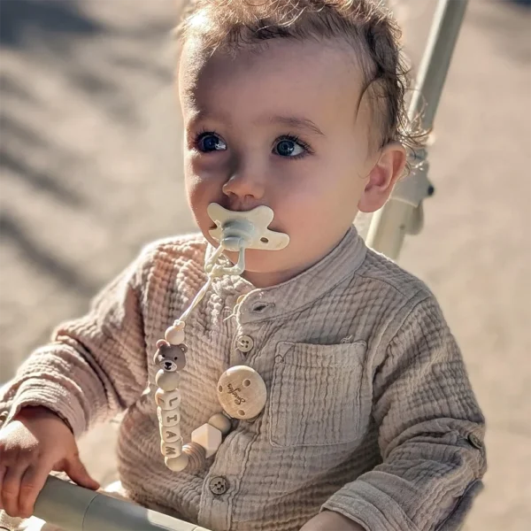 Baby met speenkoord van siliconen kralen in natuurlijke kleuren – veilig, stijlvol en gepersonaliseerd speenkoord met naam Liam en schattige beertje, ideaal voor dagelijks gebruik om speen niet te verliezen.