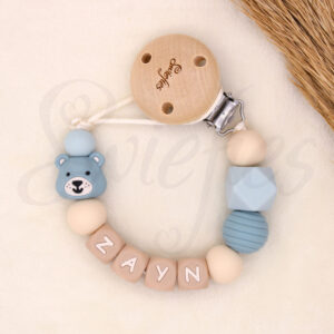 Gepersonaliseerd speenkoord met naam ‘Lily’. Gemaakt van siliconen kralen, een schattige roze beer, crème letterkralen en een houten clip. Ideaal als kraamcadeau.