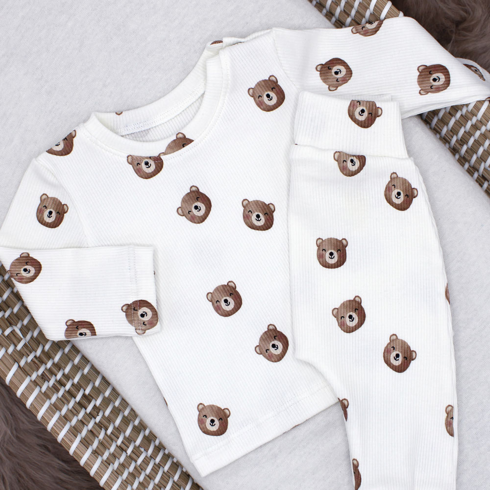 Een broekje met beer. Rib. Een wit shirtje met lange mouwen en teddybeertjes. Leuke en unieke babykleding met beertjes.