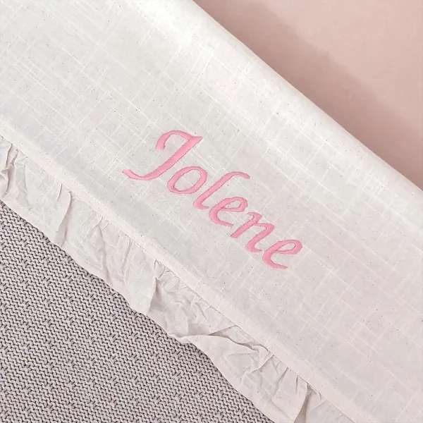 Gepersonaliseerd beige babylaken met roze geborduurde naam ‘Jolene’ en elegante ruches, ideaal als kraamcadeau.