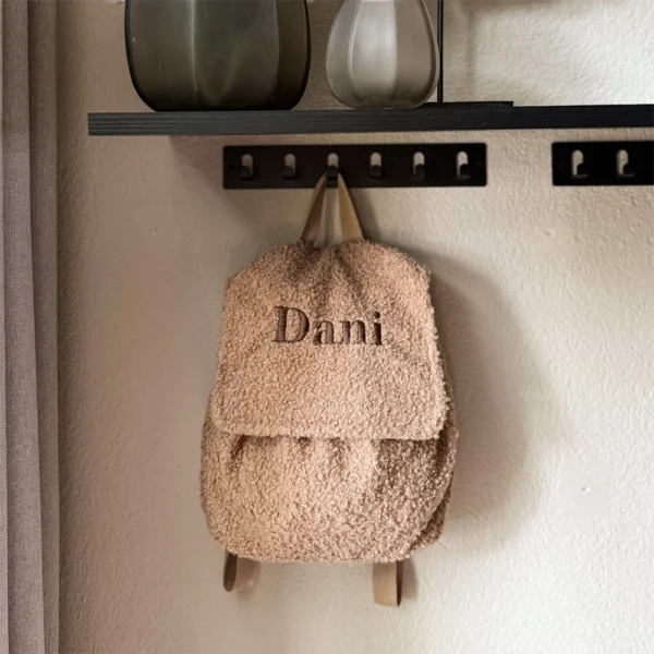 Zachte teddy rugzak met naam ‘Dani’, gepersonaliseerd met donkerbruin borduursel. Ideaal als peuterrugzak of kraamcadeau.