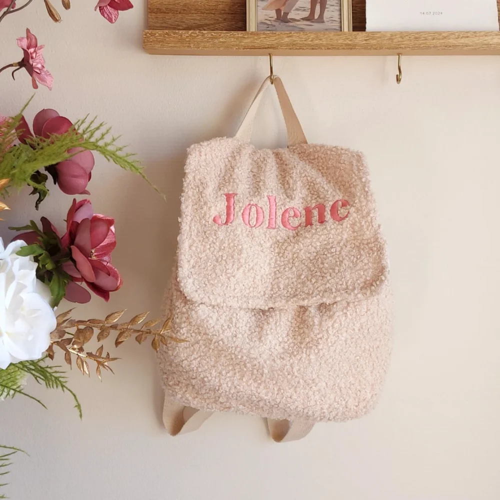 Gepersonaliseerde teddy rugzak met de naam “Jolene” geborduurd in roze letters. Zachte en stijlvolle kinderrugtas, ideaal voor school, opvang of een dagje uit. Perfect als uniek en praktisch cadeau voor kinderen.