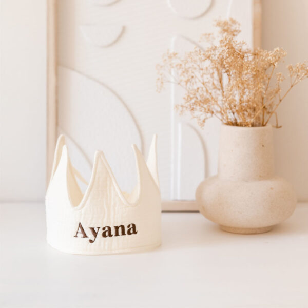 Een katoen kroonvormig feesthoedje in de kleur Ivoor, gepersonaliseerd met de naam “Ayana”. Dit kroontje met naam is perfect als cadeau voor verjaardagen of feestelijke gelegenheden.
