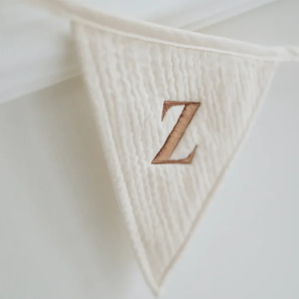 Gepersonaliseerde vlaggenlijn van zachte crème hydrofiele stof. Vlaggetje met geborduurde letter “Z”, perfect als decoratie voor babykamer, kinderkamer of feestelijke gelegenheden zoals een geboorte of verjaardag. Slinger met naam.