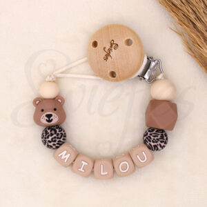 Gepersonaliseerd speenkoord met beertje en naam Milou in neutrale aardetinten, gemaakt van siliconen kralen met panterprint en houten clip met merknaam Swiefies. Stijlvol en veilig voor bevestiging van de speen.