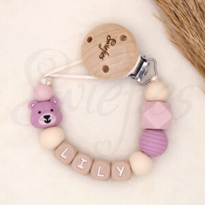 Gepersonaliseerd speenkoord met naam ‘Lily’. Gemaakt van siliconen kralen, een schattige roze beer, beige letterkralen en een houten clip. Ideaal als kraamcadeau.